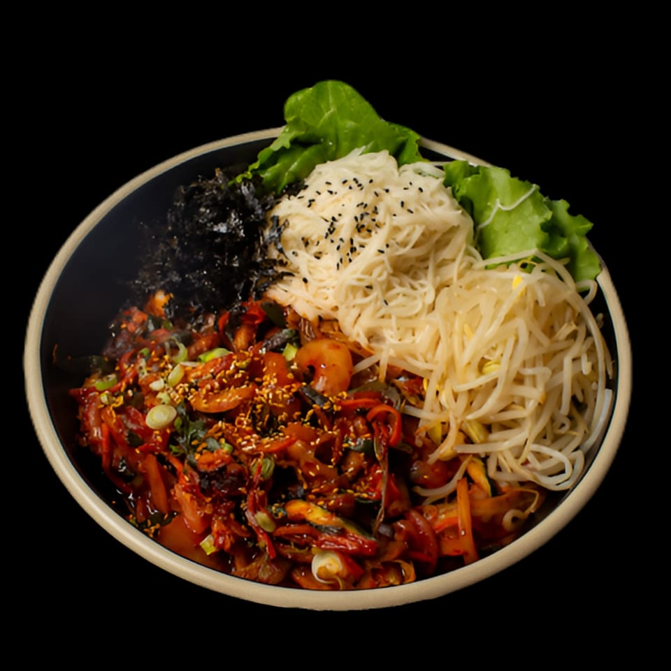 A Korean dish with spicy red sauce, noodles, bean sprouts, seaweed, and lettuce in a bowl.