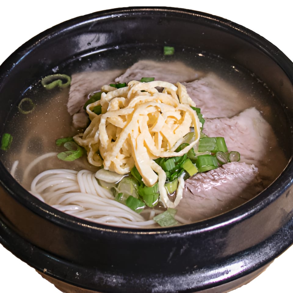Garionban's Korean beef soup with noodles, sliced beef, egg strips, and green onions in a black bowl.